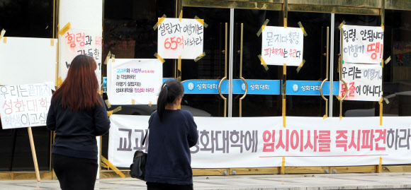 “어디서 공부하나” 7일 오전 전남 강진의 성화대에서 학생들이 퇴출 반대와 학교 정상화를 요구하는 현수막과 피켓이 나붙은 본관 앞을 지나고 있다. 강진 연합뉴스