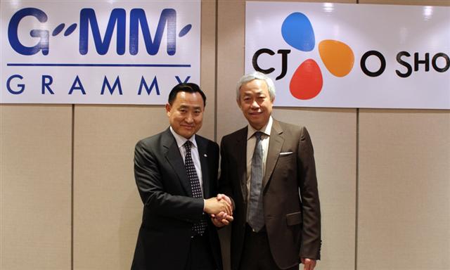 CJ오쇼핑 이해선(왼쪽) 대표이사가 7일 태국 최대 엔터테인먼트그룹 GMM그래미 파이분 회장과 태국 홈쇼핑 진출을 위한 합작투자 계약서에 서명한 뒤 악수하고 있다.  CJ오쇼핑 제공