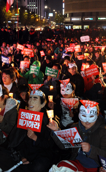 13일 저녁 서울 시청 앞 서울광장에서 한·미 자유무역협정(FTA) 국회 비준을 반대하는 전국노동자대회가 열린 가운데 ‘한·미 FTA 저지 범국민운동본부’ 회원들이 FTA 폐기를 촉구하는 구호를 외치고 있다. 이언탁기자 utl@seoul.co.kr