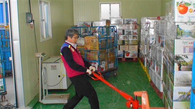 임기건(52) 주왕산우체국 사무장이 우체국 집하장에 쌓여 있는 지역특산품 주왕산사과를 손지게차를 이용해 택배차량으로 옮기고 있다.