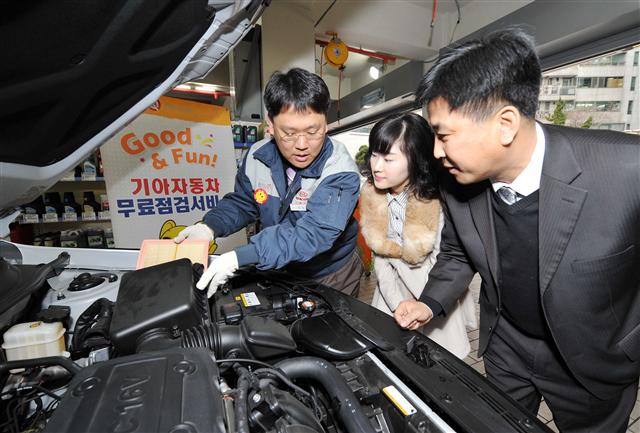 기아자동차의 연말연시 특별 무상점검 서비스 행사에서 기아차 정비직원이 고객들에게 자동차 월동 준비에 대한 설명을 하고 있다.  기아차 제공