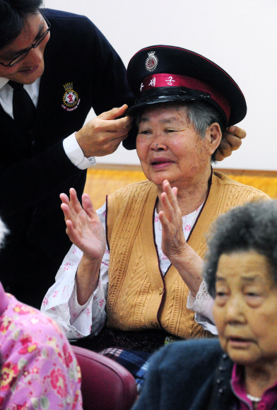 ▲ 구세군사관학교 교육일정에 포함된 양로원 방문 시간에 한 사관이 할머니에게 모자를 씌워주고 있다.