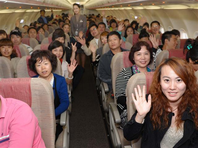 지난해 10월부터 아시아나항공이 운영하는 국내 최초 중국인 관광객 전용기인 인천발 제주행 ‘제주쾌선(濟州快線)’에 탑승한 중국인 승객들이 11일 기념촬영을 하고 있다.  아시아나항공 제공