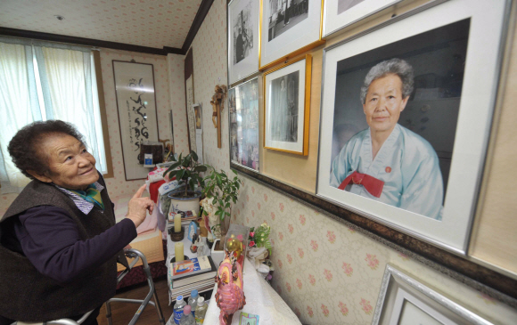 일본군 위안부 피해자 김군자 할머니가 지난 12일 경기 광주 나눔의 집에서 미리 찍어 둔 자신의 영정사진을 바라보며 회한에 잠겨있다. 정연호기자 tpgod@seoul.co.kr