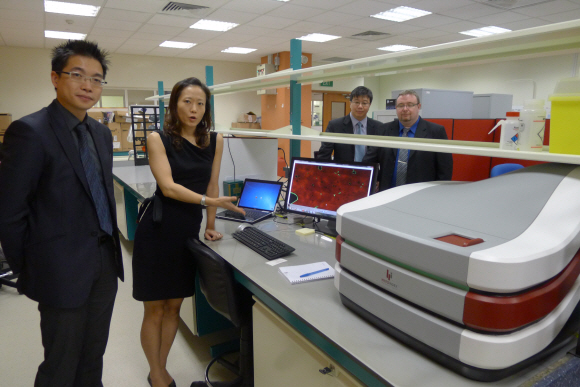 히스토인덱스에서 레이저와 컴퓨터를 결합해 만든 초정밀 암세포 진단기의 기능을 한 직원이 설명하고 있다. 개발자 딘 타이(왼쪽)·기디온 호(오른쪽 두 번째) 두 청년 과학자가 설명 도중 싱가포르 공공기관들의 연구 지원 과정을 상세하게 덧붙였다.