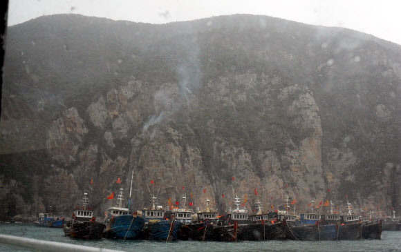 22일 산불이 발생한 전남 신안군 홍도에 연기가 피어 오르고 있는 가운데 중국 어선 수십척이 강풍을 피해 정박해 있다. 신안 연합뉴스