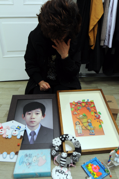 지난해 10월 의문의 죽음을 당한 오승훈군의 어머니가 아들이 생전에 만들었던 점토 작품과 영정 사진을 내보이며 눈물을 흘리고 있다. 도준석기자 pado@seoul.co.kr