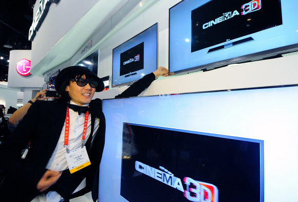 11일 오전 (현지시간) 가수 김장훈(오른쪽 사진)이 ‘CES 2012’ LG전자 부스에서 세계 최소 두께인 1㎜베젤 ‘시네마 스크린’ 디자인의 3DTV 신제품을 시연하고 있다.  연합뉴스