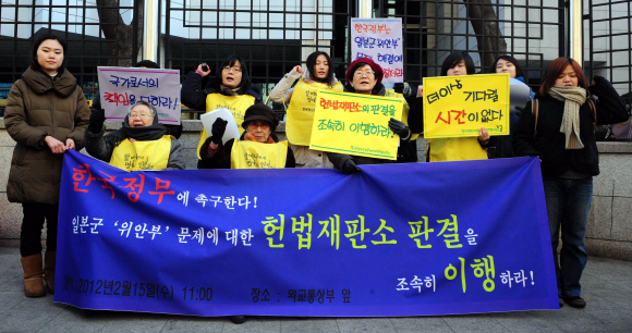 15일 오전 정부종합청사 별관 후문에서 열린 일본군 위안부 문제에 대한 헌법재판소 판결의 조속한 이행을 촉구하는 기자회견에 참석한 참가자들이 구호를 외치고 있다. 박지환 popocar@seoul.co.kr