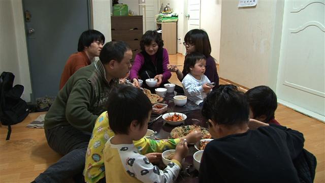 좁은 공간에 모여 식사를 하는 진호씨네 열 식구. 삶은 팍팍하지만 다섯 아이들을 보며 행복과 희망을 그리고 있다. KBS1 제공