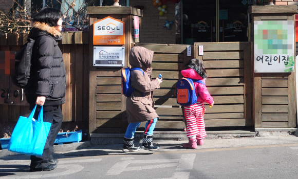 민간 어린이집 집단휴원 첫날인 27일 오전 서울 관악구 한 어린이집 앞에서 한 학부모가 자녀의 등원 모습을 지켜보고 있다.  박지환기자 popocar@seoul.co.kr