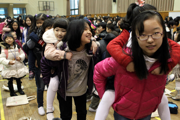 6학년 언니 등에 업힌 1학년  2일 오전 경남 창원 가음정동 성주초등학교 체육관에서 열린 입학식에서 6학년 언니들이 새내기들을 업어주고 있다. 창원 연합뉴스