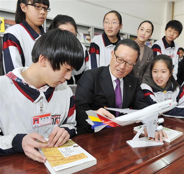 윤영두(앞줄 가운데) 아시아나항공 사장이 22일(현지시간) 중국 지린성 옌볜조선족자치주 투먼시 제5중학교를 찾아 ‘1지점 1교’ 자매결연을 맺고 학생들에게 모형비행기를 보여주며 비행 원리에 대해 설명하고 있다.  아시아나항공 제공