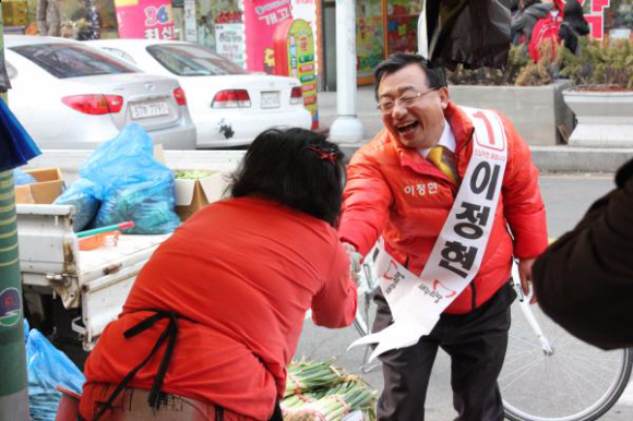 민주통합당의 텃밭인 광주 서구을에서 출사표를 던진 새누리당 이정현 후보가 지난달 23일 한 상인과 악수하며 지지를 호소하고 있다.