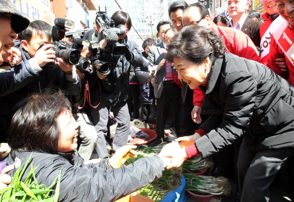 박근혜(오른쪽) 새누리당 선거대책위원장이 25일 울산 중구 태화시장을 방문해 상인과 악수를 하며 지지를 부탁하고 있다. 연합뉴스