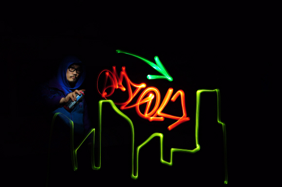 ‘스트리트 보이’라는 캐릭터로 주목받고 있는 그라피티 라이터 홍삼이 불꺼진 갤러리에서 스프레이 페인트 대신 빛을 이용해 그라피티 작품을 그리고 있다.  