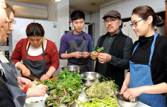 음식발전소 스튜디오에서 이종국(오른쪽에서 두 번째)씨가 직원들에게 봄나물 요리에 대해 얘기하고 있다. 