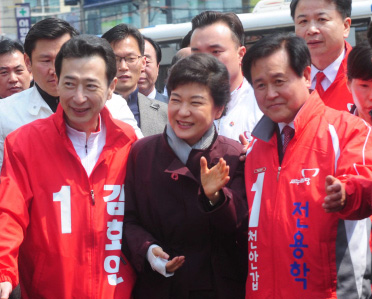 새누리당 박근혜(가운데) 선대위원장이 8일 충남 천안시 쌍용동에서 김호연(왼쪽)·전용학(오른쪽) 후보의 안내를 받으며 유권자들에게 인사하고 있다. 안주영기자 jya@seoul.co.kr