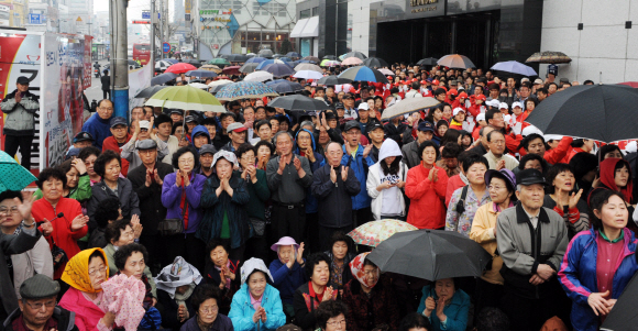 누굴 찍을까…우산도 잊은 채  ‘4·11 선택’을 하루 앞둔 10일 오후 서울 신촌의 한 길거리. 빗속에서도 유세를 듣기 위해 가득 모인 유권자들이 우산도 받쳐들지 않은 채 집중하고 있는 모습이 뜨거운 선거 열기를 느끼게 한다. 김명국기자 daunso@seoul.co.kr 