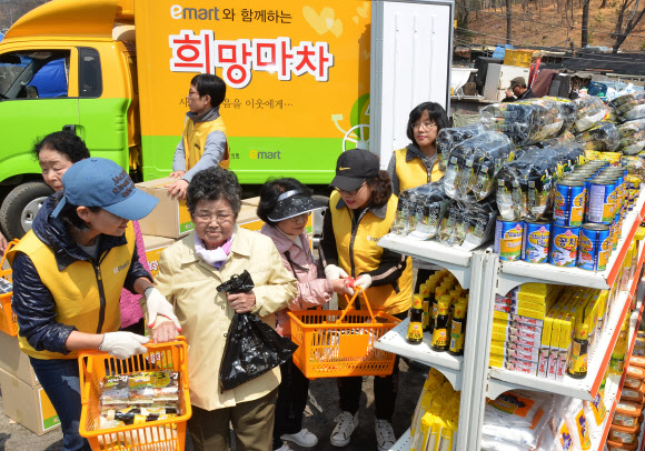 17일 서울 서초구 방배동 전원마을 비닐하우스촌에서 이마트 임직원들이 주민들에게 생필품을 나눠주고 있다. 연합뉴스