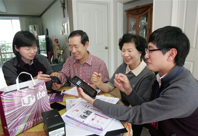 LG유플러스 직원들이 26일 서울 성북구 돈암동에 거주하는 고객의 집을 방문해 스마트폰과 태블릿PC를 개통하고 이용방법을 설명하고 있다. LG유플러스 제공