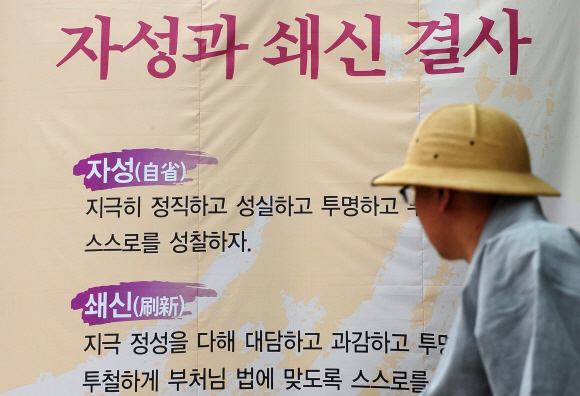 승려 호텔 도박 사건과 관련, 자성과 쇄신을 촉구하기라도 하듯 11일 서울 견지동 조계종 총무원 앞에 걸린 현수막을 한 승려가 보고 있다.  박지환기자 popocar@seoul.co.kr