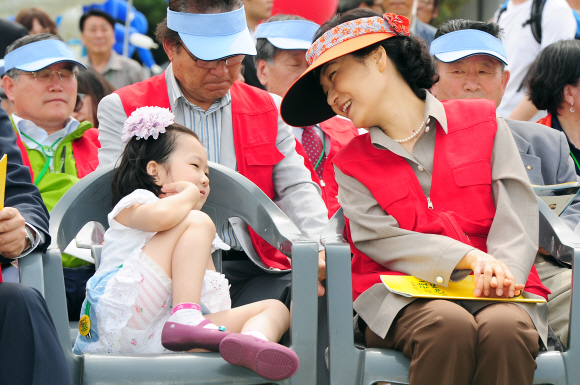 박근혜(오른쪽) 새누리당 전 비상대책위원장이 19일 오후 서울 여의도 국회의사당 앞에서 열린 ‘국회 동심한마당’ 행사에서 옆에 앉은 한 어린이를 바라보며 활짝 웃고 있다. 뉴스1