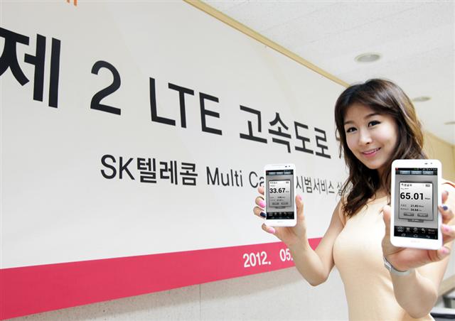 SK텔레콤 도우미가 30일 서울 강남역 인근에서 두 개의 주파수를 사용하는 멀티캐리어 서비스의 속도를 측정한 후 LTE 스마트폰에 기록된 결과를 보여 주고 있다. SK텔레콤 제공