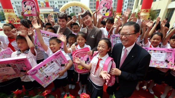 1일 중국 산둥성 웨이하이의 반월만소학교에서 윤영두(앞줄 오른쪽) 아시아나항공 사장과 직원들이 소학교 학생들에게 학용품을 나눠주자 중국 학생들이 좋아하고 있다. 공항 사진기자단 