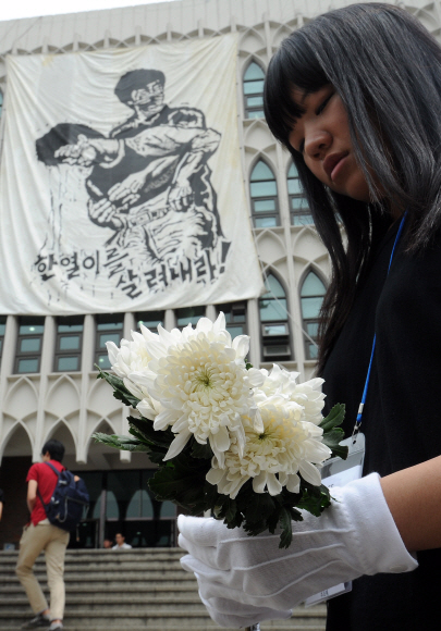 8일 오후 서울 서대문구 연세대에서 열린 ‘고 이한열 열사 25주기 추모제’에서 한 여학생이 국화꽃을 들고 있다. 뉴스1