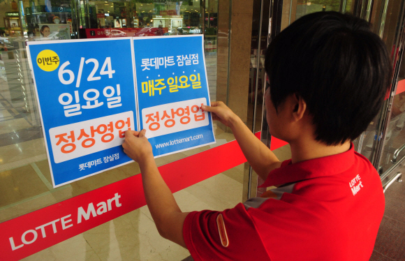 “이번 일요일 영업합니다”  대형마트와 기업형 슈퍼마켓의 의무휴업일 지정이 부당하다는 법원 판결에 따라 22일 서울 송파구 잠실의 대형마트 직원이 일요일(24일), 영업을 알리는 안내문을 서둘러 붙이고 있다. 박지환기자 popocar@seoul.co.kr