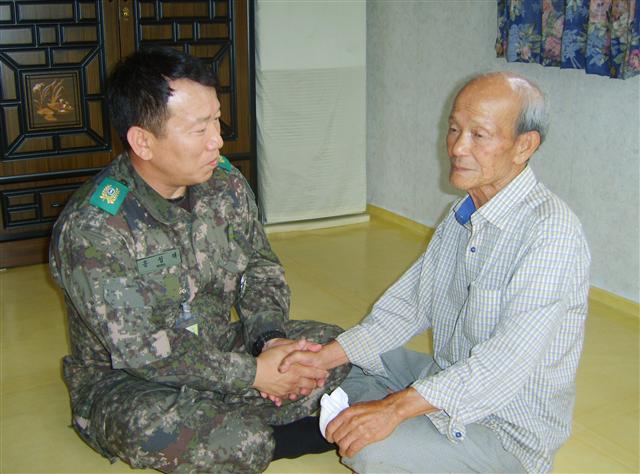 홍성태(왼쪽) 축산면대장이 21일 무공훈장 수훈자인 김도현(85) 옹을 찾아 6·25전쟁 당시 활약상에 대해 듣고 있다.  육군 제공