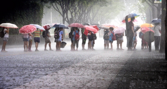 장마전선이 북상하면서 서울과 인천 등 중부지방에 호우주의보가 내려진 가운데 5일 서울 세종로 사거리 버스정류장에서 초등학생들이 우산을 쓰고 버스를 기다리고 있다. 기상청은 이날 서울에 최고 100㎜ 이상의 많은 비가 내린 데 이어 6일까지 중부지방에 최고 120㎜가 넘는 폭우가 쏟아질 것이라고 예보했다. 류재림기자 jawoolim@seoul.co.kr