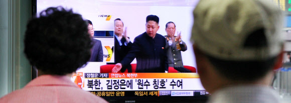 시민들이 서울역에 설치된 TV를 통해 북한이 18일 낮 12시 김정은 국방위원회 제1위원장에게 원수 칭호를 부여한다는 뉴스 속보를 보고 있다.  연합뉴스