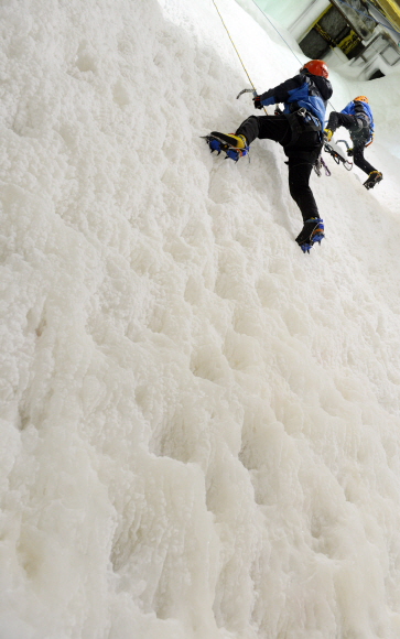 코오롱 등산학교 빙벽장에서 한 클라이머가 깎아지른 빙벽을 오르고 있다.