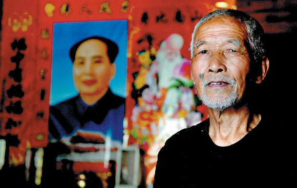 쑤이창현 사람들은 늘 입가에 미소를 달고 산다. 마오쩌둥의 초상화 앞에 선 반링춘의 노인.