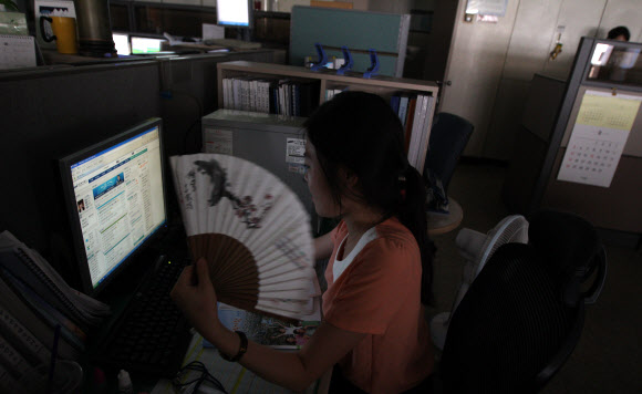 계속된 폭염으로 이틀째 전력경보 ‘주의’가 발령된 7일 오후 삼성동 한국전력거래소에서 직원들이 실내등과 선풍기를 끄고 업무를 보고 있다.  연합뉴스