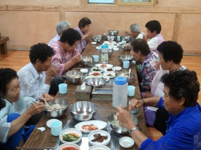 단양지역 독거노인들이 지난달 25일 단양읍 도전리의 조선면옥이 제공한 삼계탕을 먹고 있다.  단양군 제공