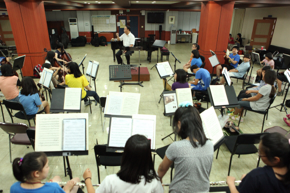 풀뿌리희망재단이 지난 1월 발족한 ‘클로버청소년오케스트라’ 어린이 단원들이 천안시립교향악단 김성한 단무장으로부터 음악 교육을 받고 있다.  풀뿌리희망재단 제공  