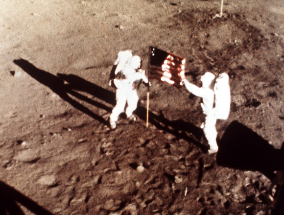 암스트롱이 아폴로 11호에 함께 탑승한 우주비행사 에드윈 버즈 올드린과 달 표면에 미국 국기를 꽂고 있다. 미국 항공우주국(NASA) 제공·