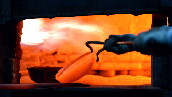 화로에서 달궈진 유기를 꺼내는 작업. 전통 방짜는 구리와 주석을 녹여 만든 쇳덩이를 섭씨 500~600도의 불길에서 거듭 담금질해 만든다.