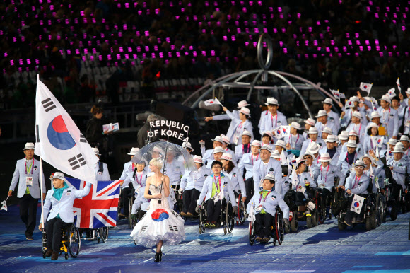 기수 김규대(왼쪽 두 번째·휠체어육상)가 든 태극기를 앞세운 대한민국 선수단이 30일 영국 런던 올림픽스타디움에서 열린 2012런던장애인올림픽 개회식에서 123번째로 입장하고 있다. 런던 연합뉴스