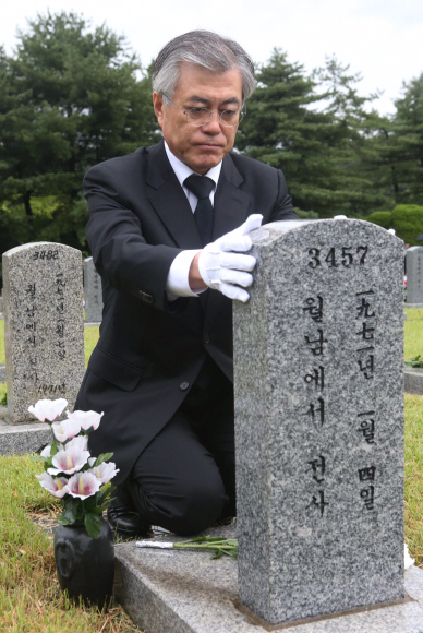 문재인 민주통합당 대선 후보가 17일 오전 서울 동작구 국립현충원 월남전 참전용사의 묘역에 헌화한 뒤 묘지석을 만지며 고인을 추모하고 있다. 이종원 선임기자 jongwon@seoul.co.kr