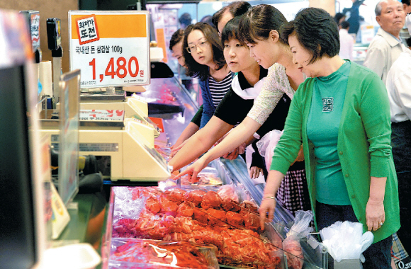 돼지고기 가격 폭락에 우는 양돈농가를 돕기 위해 이마트가 23일 서울 성동구 성수점에서 마련한 소비촉진 행사에서 시세보다 20% 싸게 나온 삼겹살(100g당 1480원)에 소비자들이 큰 관심을 보이고 있다. 이종원 선임기자 jongwon@seoul.co.kr