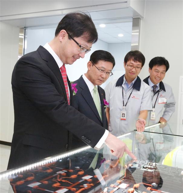 최재원(왼쪽) SK그룹 수석부회장과 구자영(가운데) SK이노베이션 사장이 전기차용 배터리를 살펴보고 있다. SK이노베이션 제공