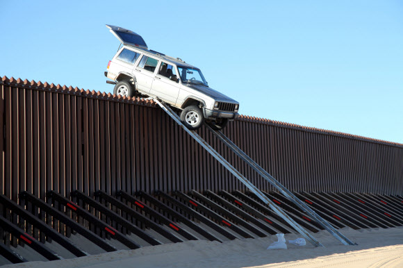 멕시코 마약 밀매꾼으로 추정되는 이들이 SUV 차량을 이용해 멕시코와 미국 간 국경 펜스를 넘으려다 꼭대기에 차가 걸리는 바람에 도망치는 웃지 못할 일이 벌어졌다.  미국 세관국경보호국 제공