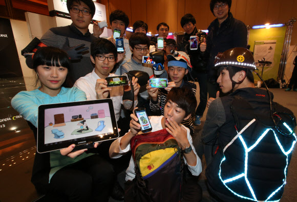 15일 서울 강남구 삼성동 코엑스에서 열린 ‘2012 웨어러블 컴퓨터 경진대회’에서 대학생들이 출품작을 들어보이고 있다.  연합뉴스