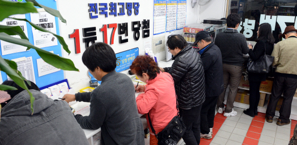 ‘로또 명당’으로 소문난 서울 노원구 상계동의 한 로또 판매점에서 손님들이 로또 용지에 자신이 고른 번호를 표시하고 있다. 이언탁기자 utl@seoul.co.kr
