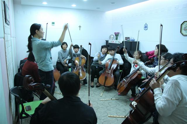 발달장애 아동들의 첼로 오케스트라 ‘날개’의 단원들이 서울 강남구 수서동 밀알복지재단에서 첼리스트 오새란(32·왼쪽)씨의 지휘에 맞춰 합주 연습을 하고 있다. 밀알복지재단 제공