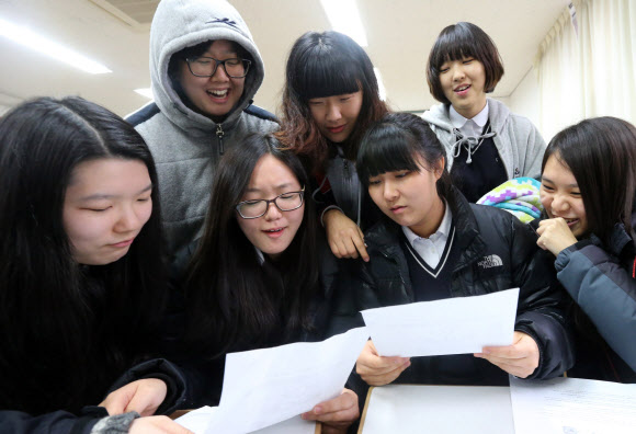 서울 풍문여자고등학교에서 수험생들이 담임교사로부터 수능성적표를 받고 점수를 확인하고 있다. 연합뉴스